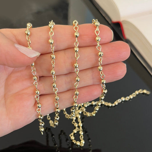Gold filled beaded chain displayed at full length showing uniform bead pattern and lustrous gold color