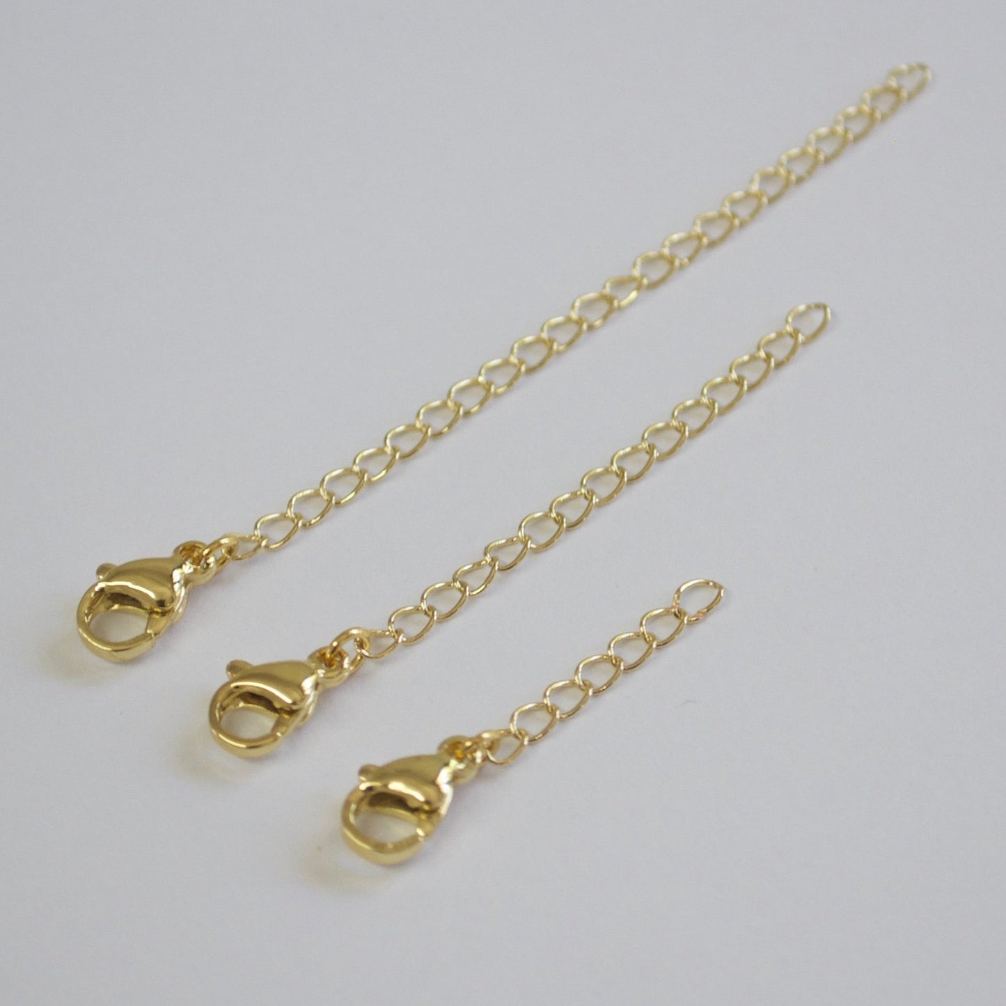 Gold chain with clasp on a light gray background