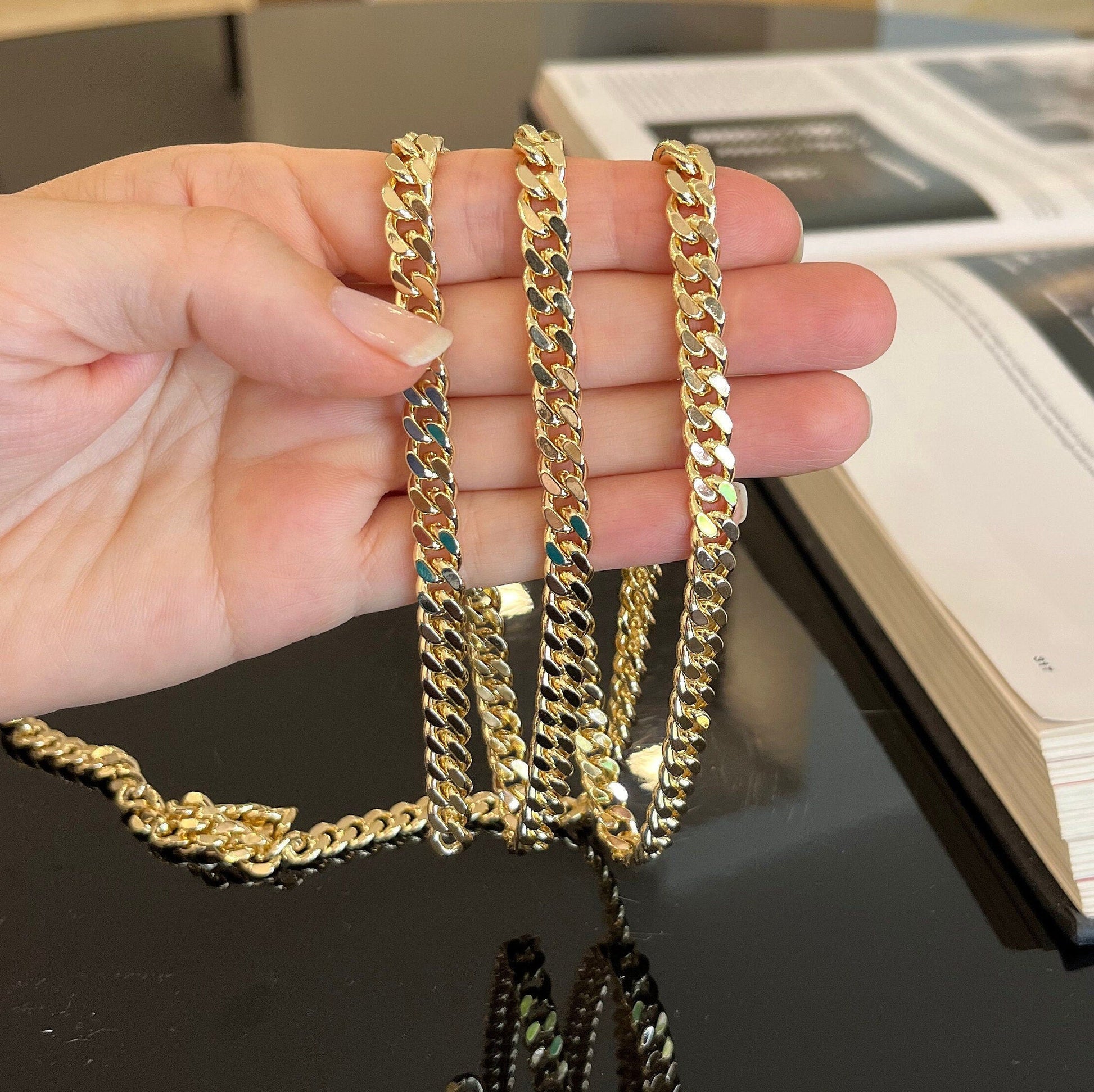 Close-up detail of 7mm gold curb chain showing texture and shine of flattened links