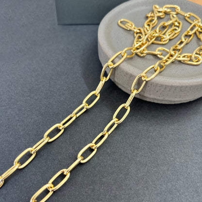Gold chain on a gray surface with a gray container in the background