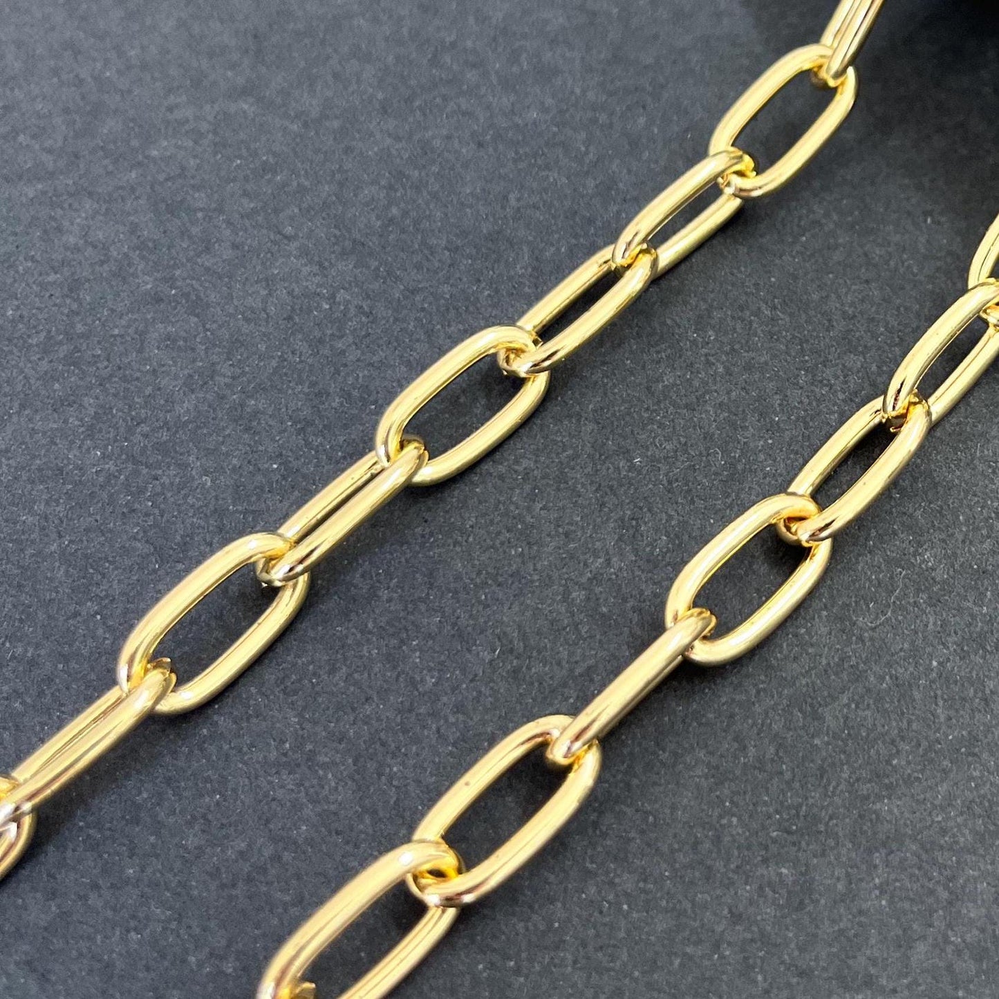 Gold large oval chain with thick chunky links displayed on grey background