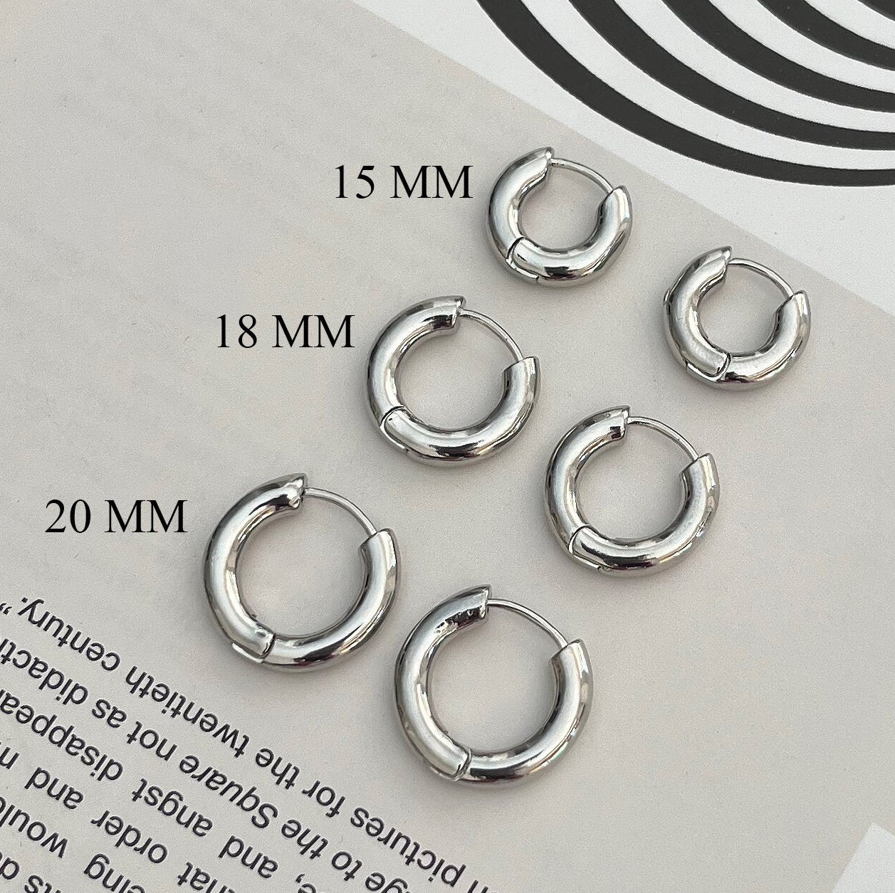 Sterling silver huggie hoop earrings - thick minimalist hoops displayed on white background