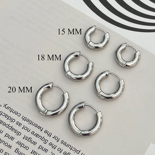 Sterling silver huggie hoop earrings - thick minimalist hoops displayed on white background